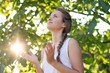 © PhotoGranary - Christian worship and praise. A young woman is praying in the early morning with sun in the background.