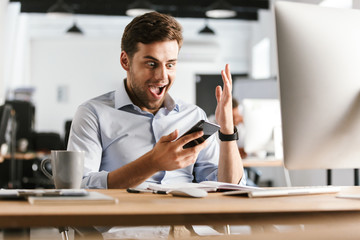 Poster - Surprised happy business man using smartphone and rejoice