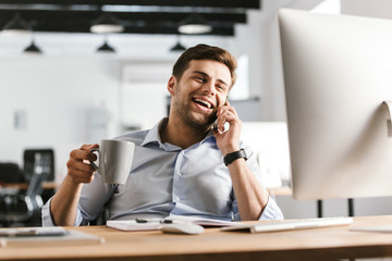 Poster - Happy business man talking by smartphone and drinking coffee