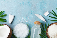 Natural Coconut Products For Spa, Cosmetic Or Food Ingredients. Oil, Water And Shavings On Blue Table Top View. Flat Lay.
