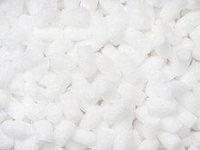 Filler Packing Background. Packaging Foam Pellets Texture, Top View, Close-up. Polystyrene, White Styrofoam Packing Peanuts Used To Prevent Damage To Fragile Objects During Shipping