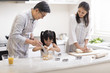 © Blue Jean Images - Happy little girl and grandparents cooking in kitchen