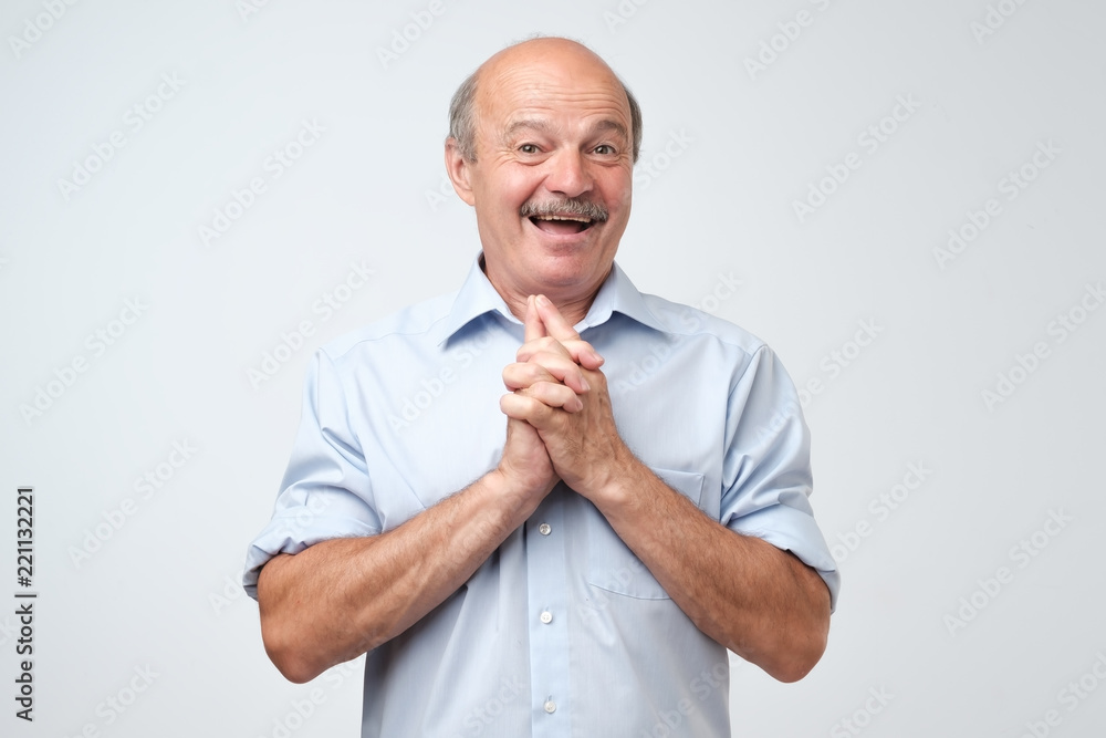 Portrait of joyful handsome mature man clapd palms, waits to hear something pleasant, recieves compliments or words of praise from boss. Positive facial expression, body language - obrazy, fototapety, plakaty 