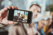 © Viacheslav Yakobchuk - Studying process. Selective focus of male hand holding smartphone and taking selfie with colleagues