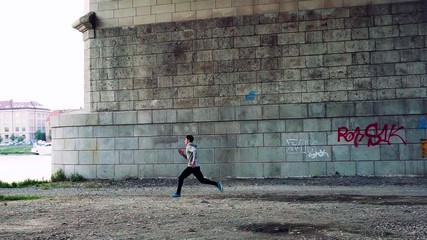 Wall Mural - Young athlete man running under the bridge in the city.