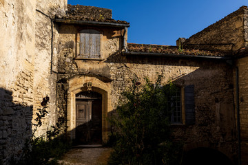 beautiful old stone building with wooden doors and shutters at sunny day, provence, france