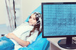 © Viacheslav Yakobchuk - Modern equipment. Selective focus on a screen of a PC displaying brain waves of a young lady lying on an examination couch while getting her brain analyzed by a electroencephalograph.