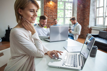 Canvas Print - Concentrated young beautiful businesswoman working on laptop in bright modern office.