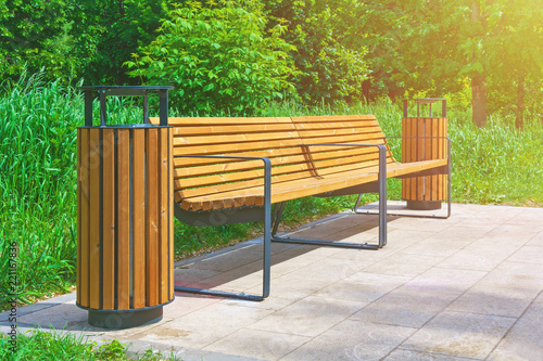 Two Wooden Benches With Garbage Cans In The Park On A Background