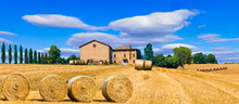 Beautiful Countryside Landscape With Hay Rolls And Farm Houses In Tuscany. Italy