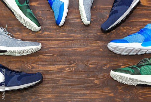 Fotografija Top view shop display of unbranded modern new stylish sneakers running shoes for men on wooden background texture with copy space