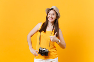 Happy traveler tourist woman in summer casual clothes, hat with retro vintage photo camera isolated on yellow orange background. Girl traveling abroad travel on weekends getaway. Air flight concept.