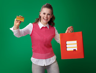 Wall Mural - student woman with shopping bag with books showing credit card