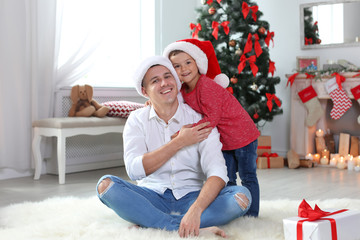 Wall Mural - Father and child in Santa hats celebrating Christmas at home