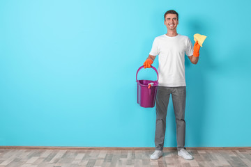 Poster - Man with cleaning supplies near color wall