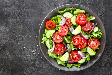 Wall Mural - Salad. Fresh vegetable salad with tomato, cucumber, lettuce and red onion