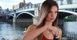 Healthy white girl in her 20s drinking from water bottle by bridge in Windsor