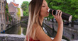 Side view of millennial woman drinking water from bottle in Bruges, Belgium