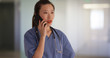 © Mark Adams - Female Medical doctor or nurse in scrubs making phone call in hospital clinic