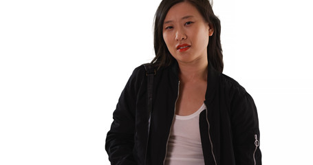 Wall Mural - Chinese woman in black bomber jacket looking at camera on white background