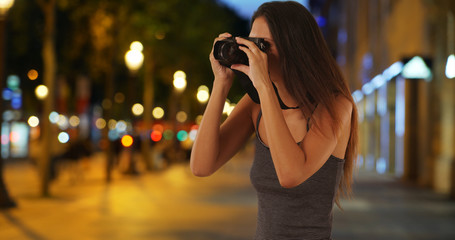 Wall Mural - Traveling girl taking picture with dslr camera on the Champs-Elysees at night