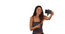 Cute Brunette Traveler Girl Using Selfie Stick In Studio With Copy Space