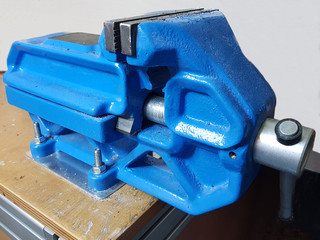 Blue adjustable  steel table vise in workshop