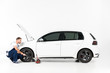 © LIGHTFIELD STUDIOS - side view of auto mechanic changing car tire on white