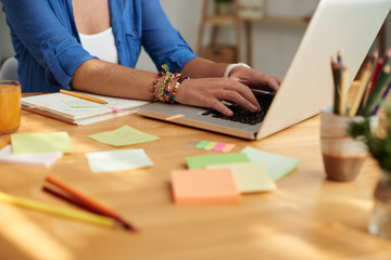 Teacher working on laptop when preparing for class at her table