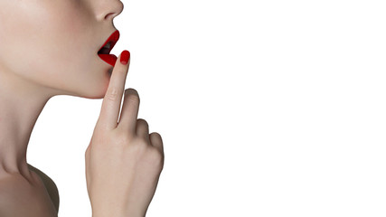 Secret. A close-up of a red lips says silent on an isolated white background. Beauty in clean skin and fashionable make-up with space for text. Spa, creative, emotions, cosmetology, advertising, nails