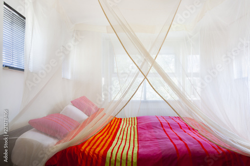 Bed With Colorful Quilt Under A Mosquito Net Kaufen Sie
