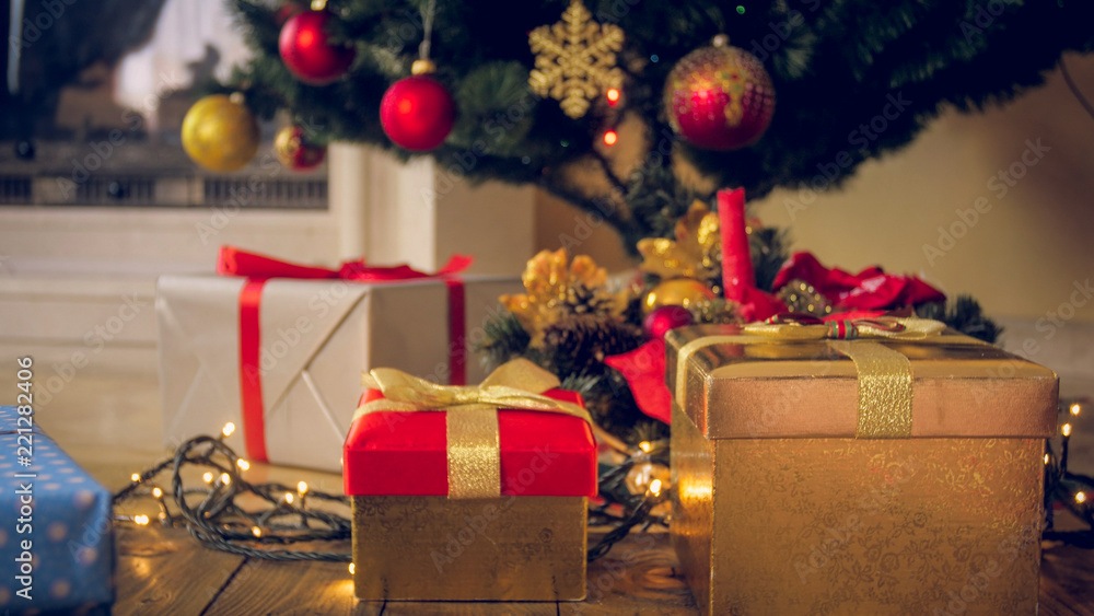 Closeup toned image of colorful gifts and presents in boxes under Christmas tree at living room - obrazy, fototapety, plakaty 