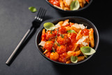 Fototapeta Kuchnia - Tasty tomato pasta in bowl on dark
