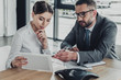 © LIGHTFIELD STUDIOS - confident businessman and businesswoman looking at tablet together at modern office