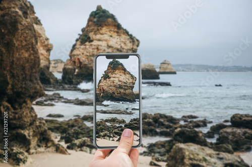 Fotografia, Obraz A tourist on the Atlantic coast in Portugal takes pictures of the beautiful views of the ocean and rocks