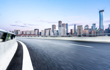 empty asphalt road with city skyline