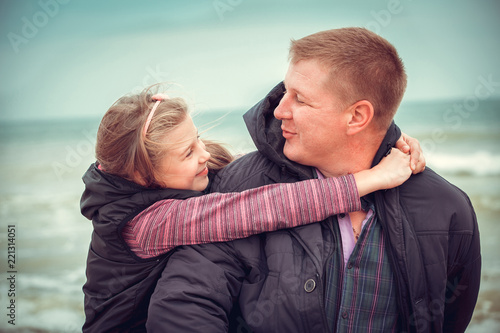 Fotografia Father And Daughter Walking On Winter Beach