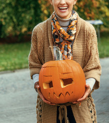 Wall Mural - woman on Halloween outdoors showing carved pumpkin