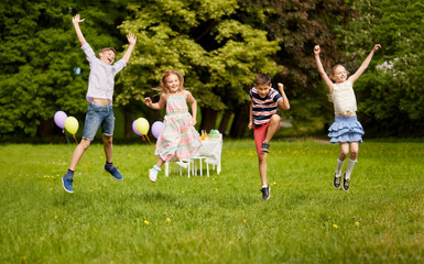 Poster - holidays, childhood and celebration concept - happy kids having fun and jumping on birthday party at summer park