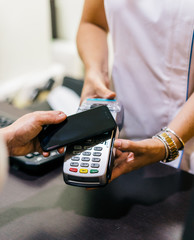 woman use smartphone to make mobile payment with electronic reader. customer paying with near field communication, NFC technology. people use app in mobile phone for online shopping.