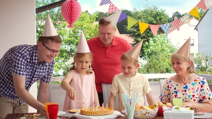 Wall Mural - Colorful portrait of happy family celebrate birthday and grandparents blows candles with children