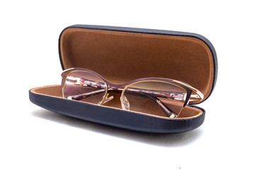 Golden sunglasses in a brown case at an angle