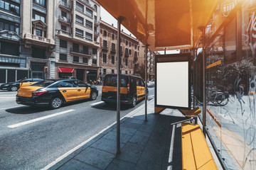 Wall Mural - Bus stop in urban settings with white mock-up banner for advertising text; an empty billboard placeholder with copy space for logo or promotion; information blank board near city road with taxi cars