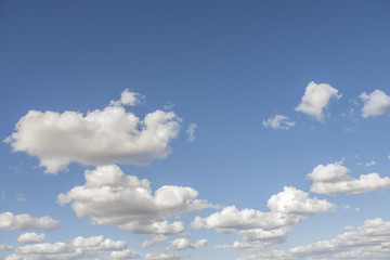 photograph of a blue sky with beautiful white clouds on a summer afternoon with sun