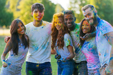 Group Of Teens Playing With Colors At The Holi Festival, In A Park