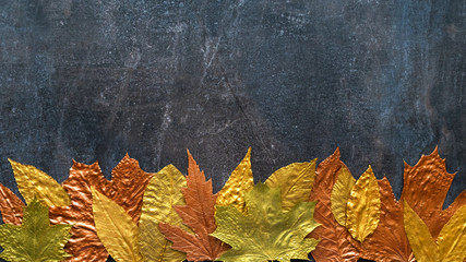 Wall Mural - Autumn metallic gold copper leaf frame. Different fall metallic paint leaves on dark natural background with copy space. Horizontal mockup with autumn leaves below