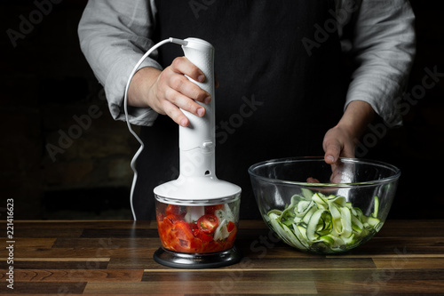 Fotografie, Obraz Chef mixing and cooking tomato traditional sauce in blender for vegetables diet salad