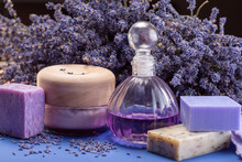Natural Healthy Aromatherapy And Skin Treatment With Organic French Lavender, Lavender Soap, Body Cream And Essential Oils On Purple Background With Dried Lavender Flowers