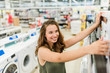 © bnenin - Woman shopping for microwave in appliances store.