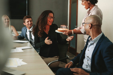 Wall Mural - Surprise birthday celebration of a female during office meeting